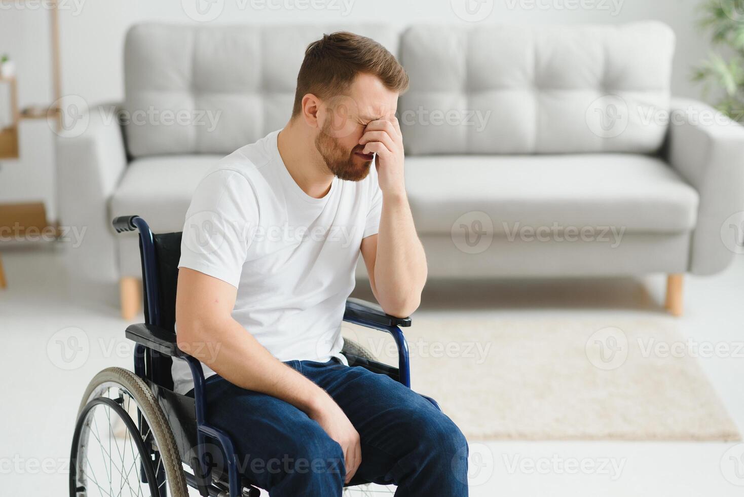 Depression and loneliness in disabled man. Elderly man in wheelchair crying indoors photo