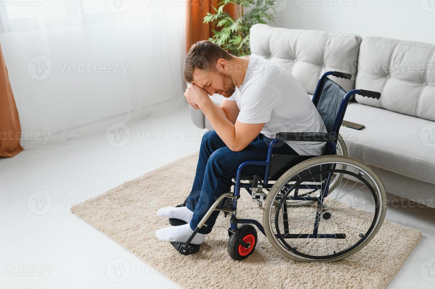 Depression and loneliness in disabled man. Elderly man in wheelchair crying indoors photo