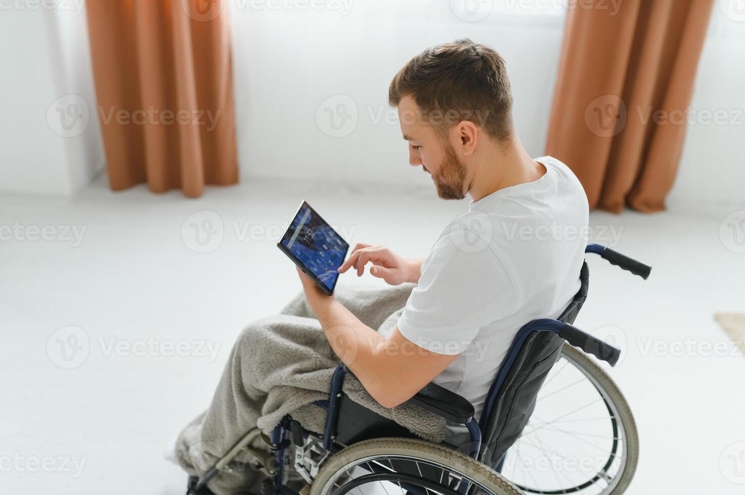 Modern young disabled man in wheelchair having video call photo