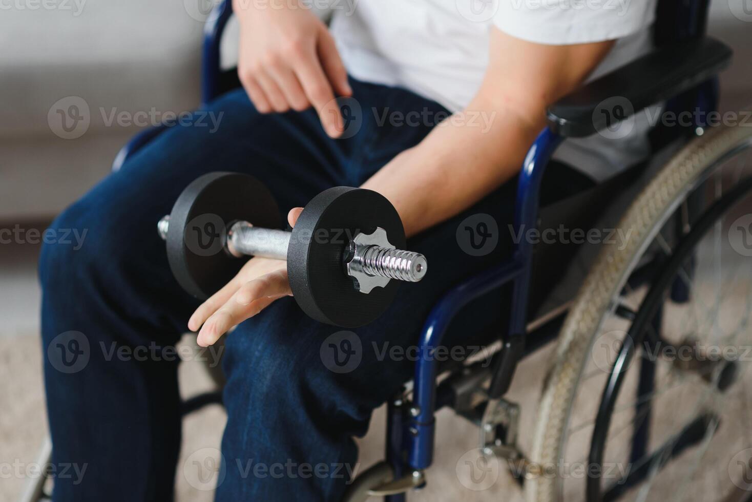 Young man in wheel-chair doing exercises indoors photo