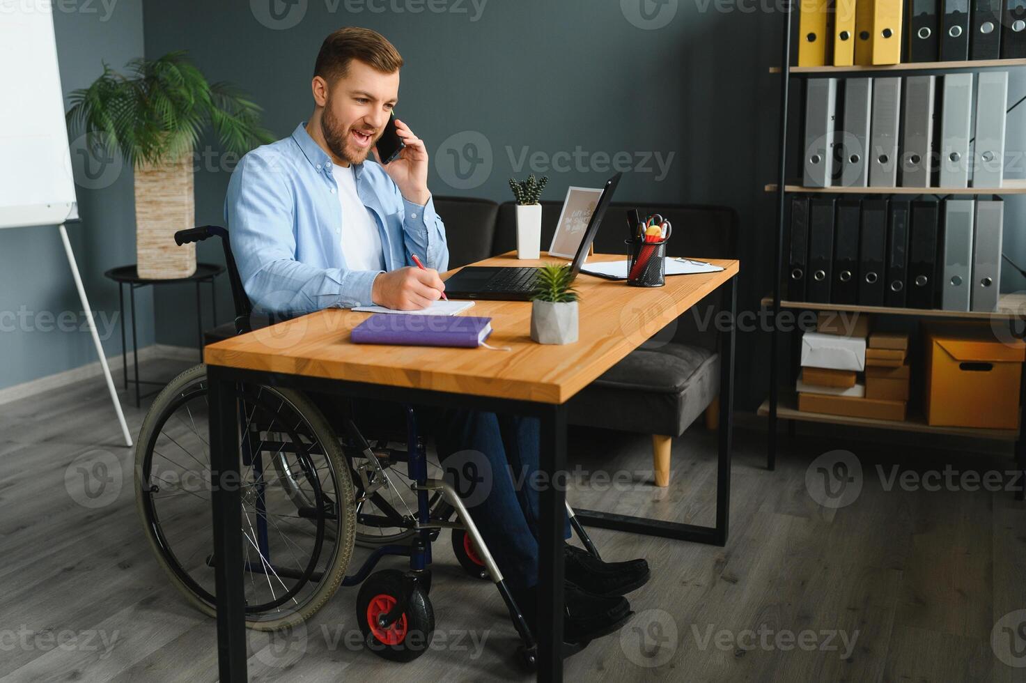 Man in wheelchair at home or in office photo