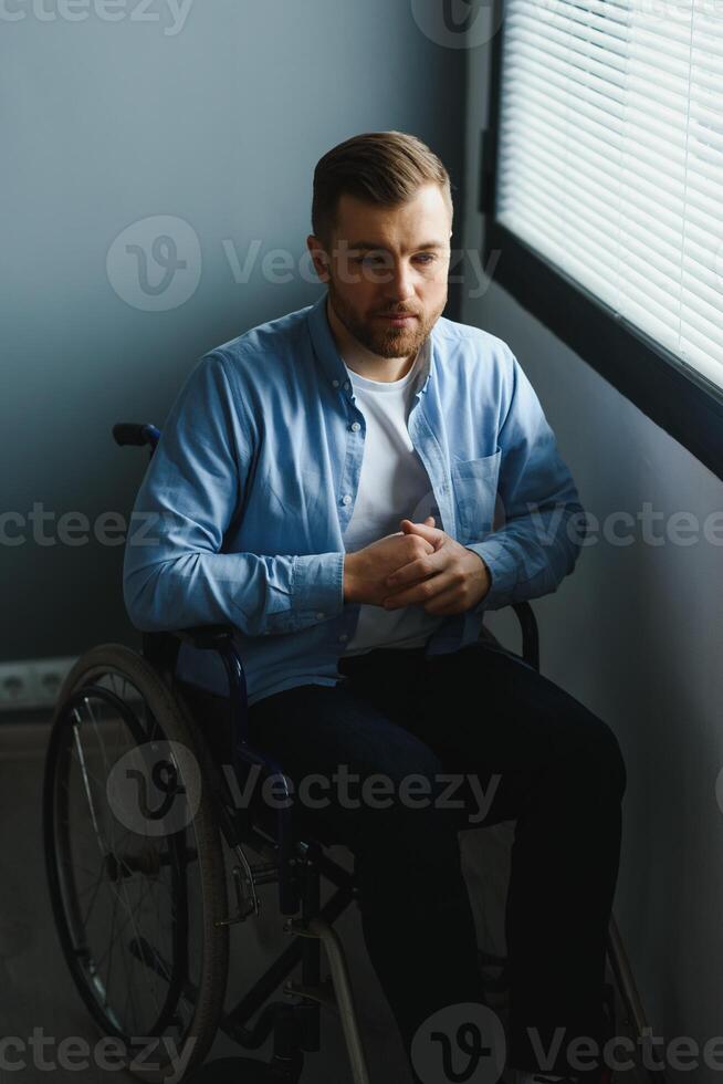 Businessman sitting on wheelchair at hospital. Sad disabled at the hospital photo