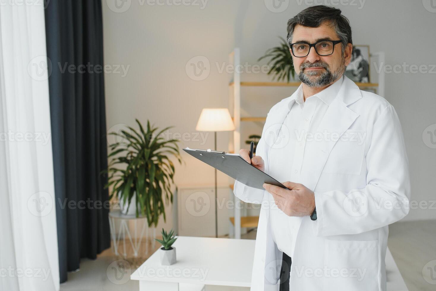 contento confidente barbado antiguo profesional médico de pie. sonriente mayor adulto médico, de confianza exitoso terapeuta vistiendo blanco laboratorio Saco y estetoscopio, retrato foto