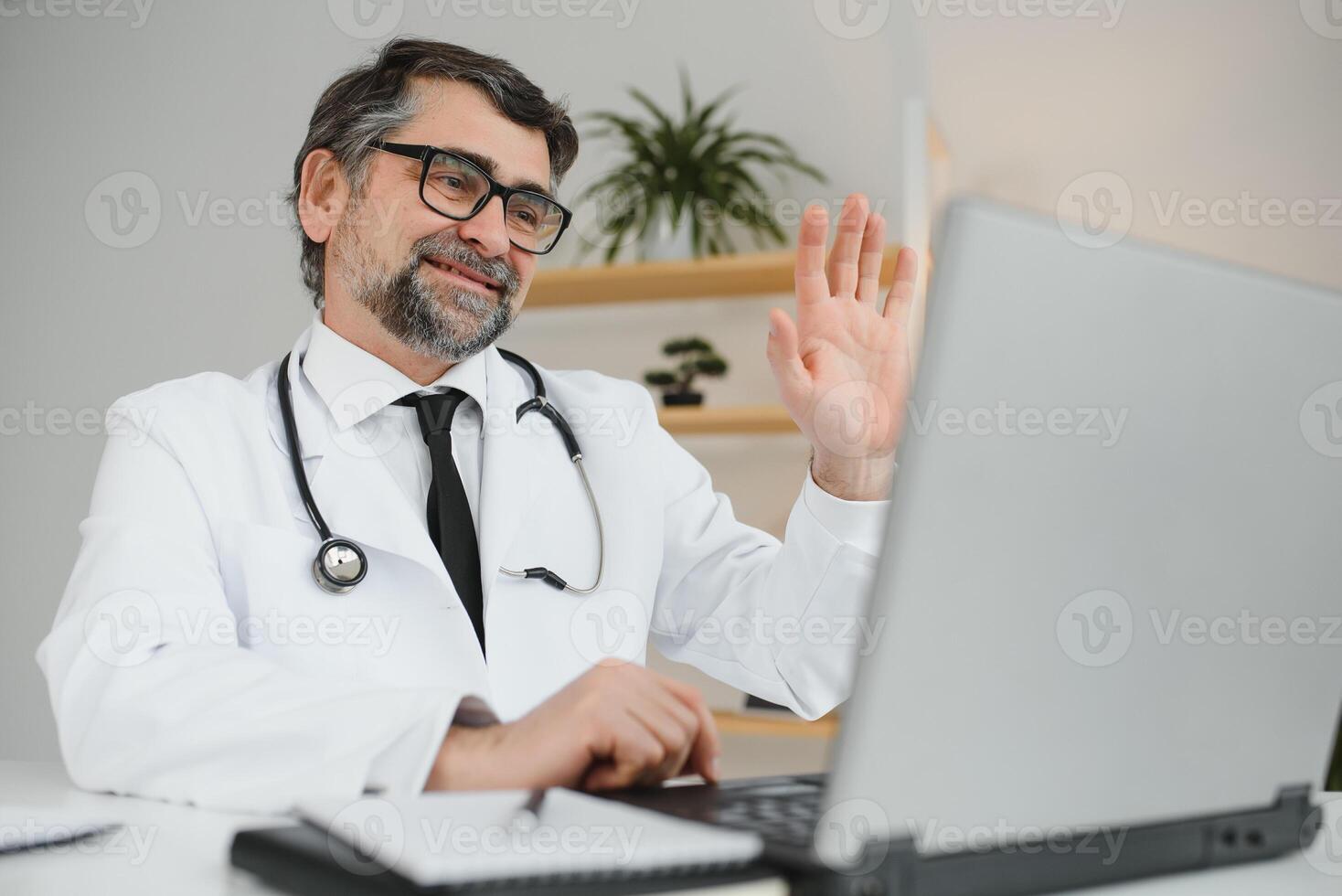 Remote medical consultation. A male doctor consults a woman has a video call conference computer monitor sitting in a clinic office photo