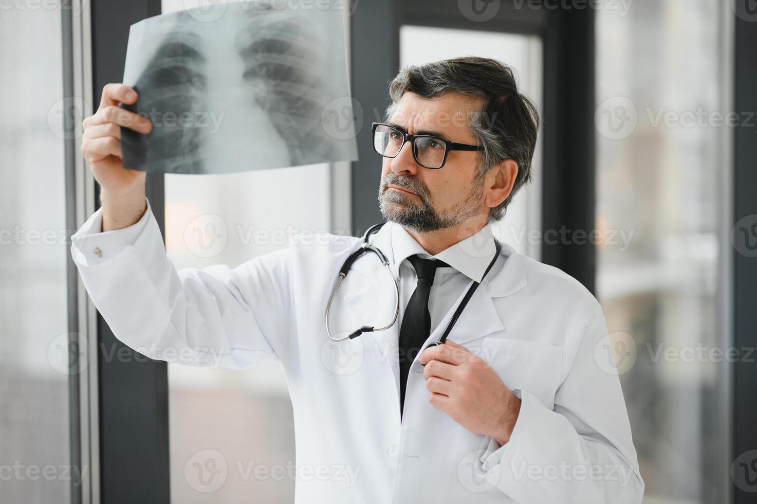 A senior doctor looking at the X-ray in his office. photo