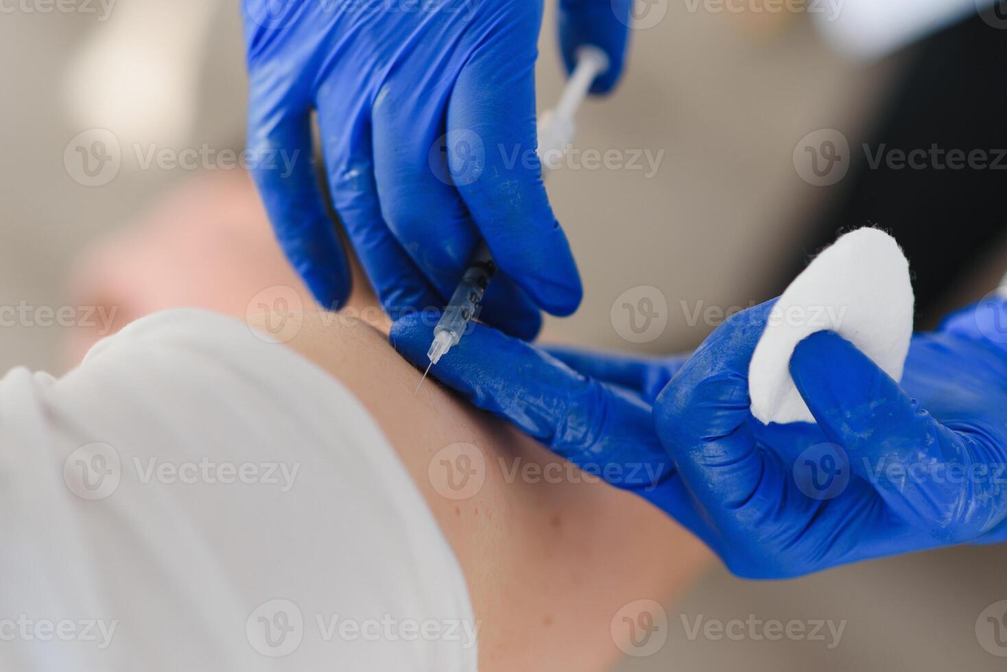 hembra médico haciendo inyectando utilizando jeringuilla a masculino paciente en hospital. mayor hombre tomando inyección para gripe en clínica. hembra médico vacunar un hombre. foto