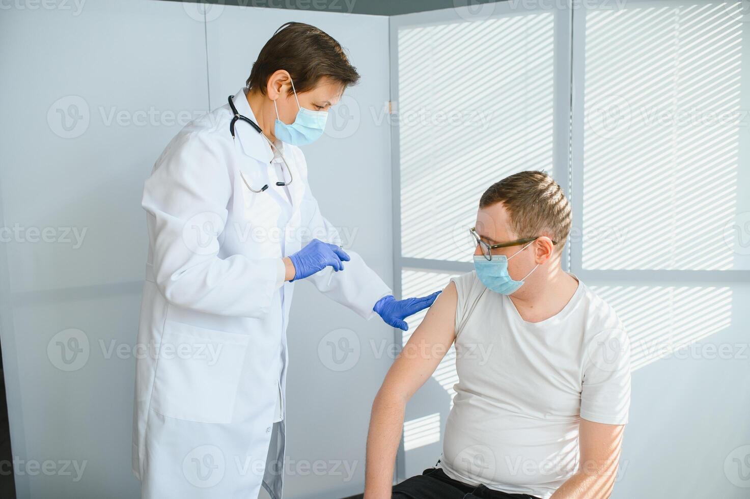 Close up of a Doctor making a vaccination in the shoulder of patient, Flu Vaccination Injection on Arm, coronavirus, covid-19 vaccine disease preparing for human clinical trials vaccination shot. photo