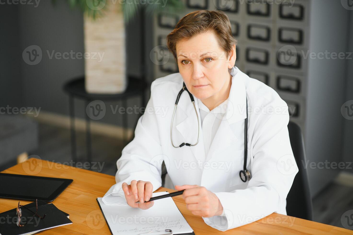 Mid age female doctor writing prescription photo