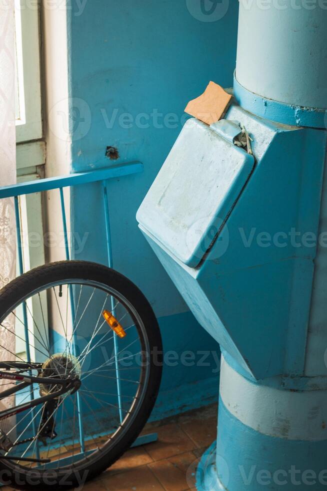 Disparo de bicicleta siguiente a el basura tolva en Soviético era corredor en el edificio, concepto foto