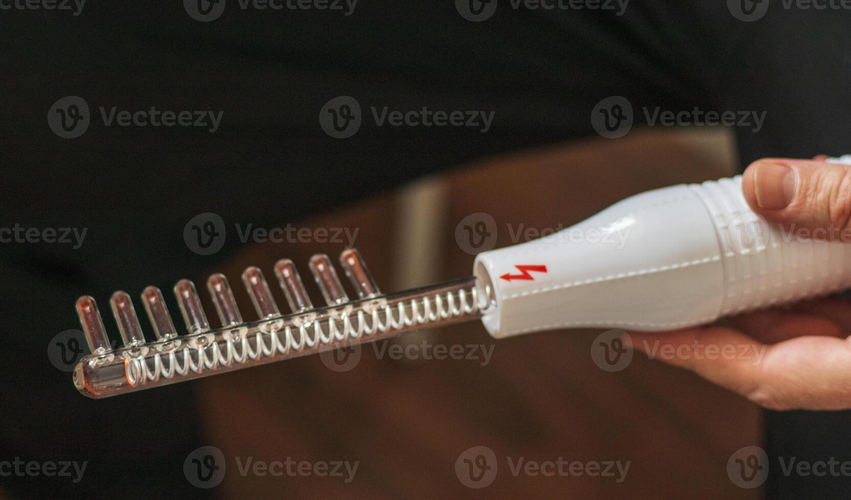 Close up shot of the high frequency comb tool for hair and scalp treatment. Healthcare photo