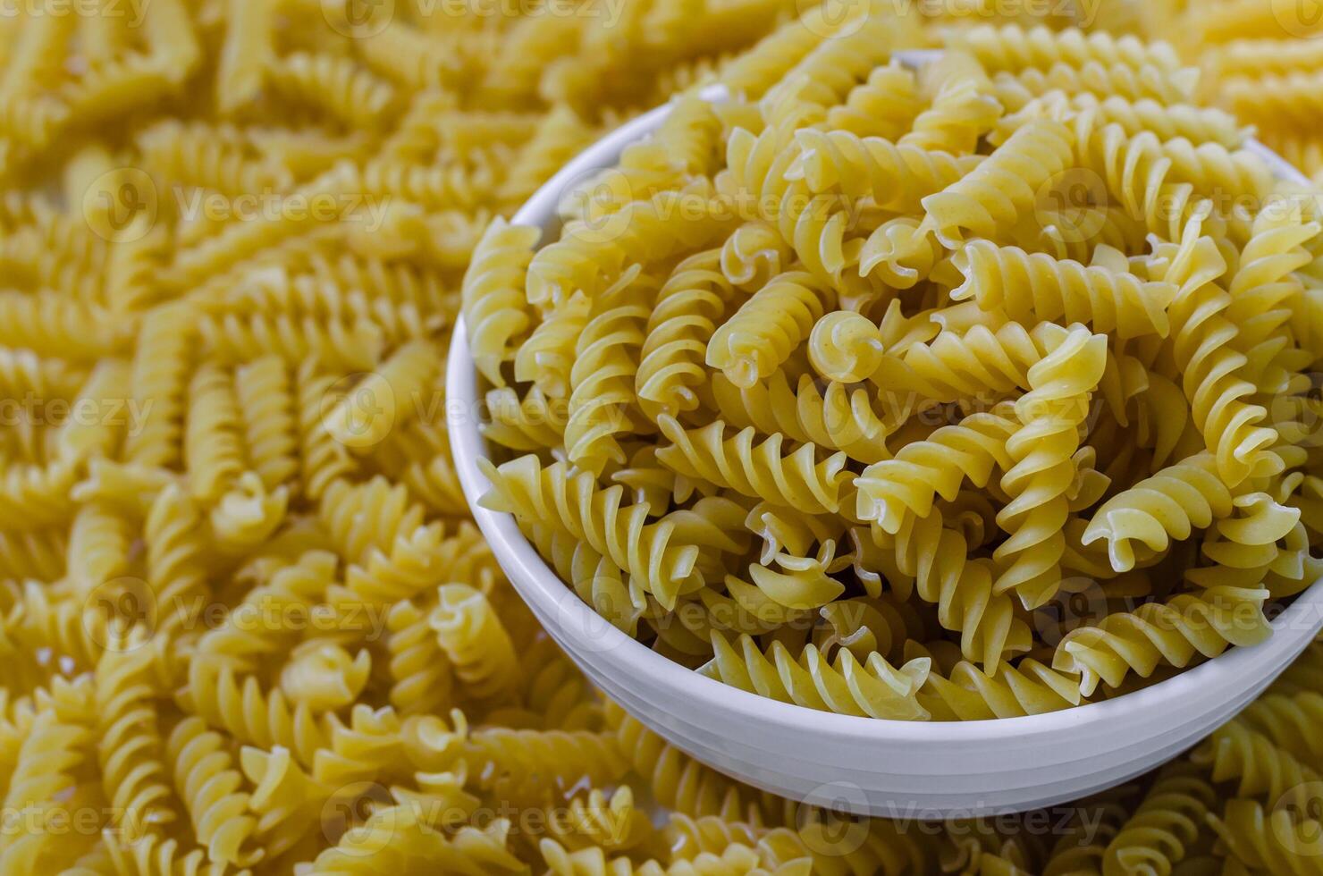 Dried Fusilli Pasta in Bowl for Cooking photo