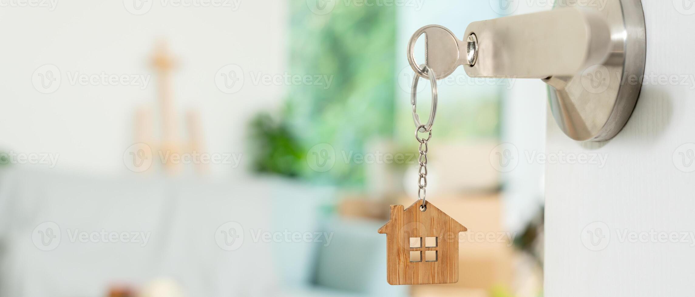 Moving house, relocation. The key was inserted into the door of the new house, inside the room was a cardboard box containing personal belongings and furniture. move in the apartment, banner photo