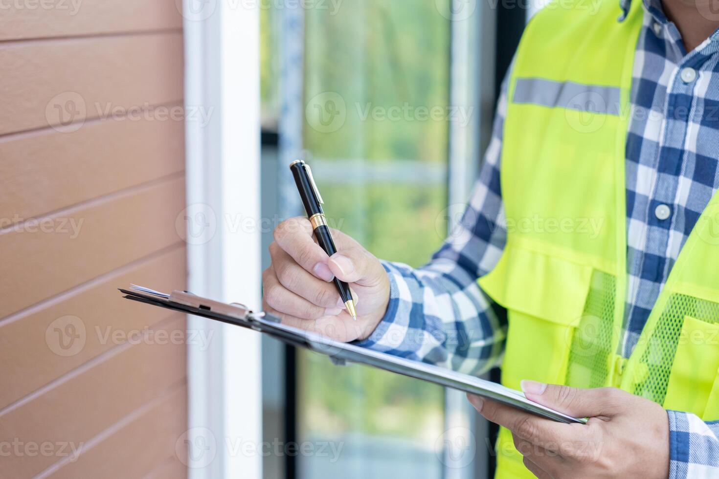 inspector or engineer is inspecting construction and quality assurance new house using a checklist. Engineers or architects or contactor work to build the house before handing it over to the homeowner photo