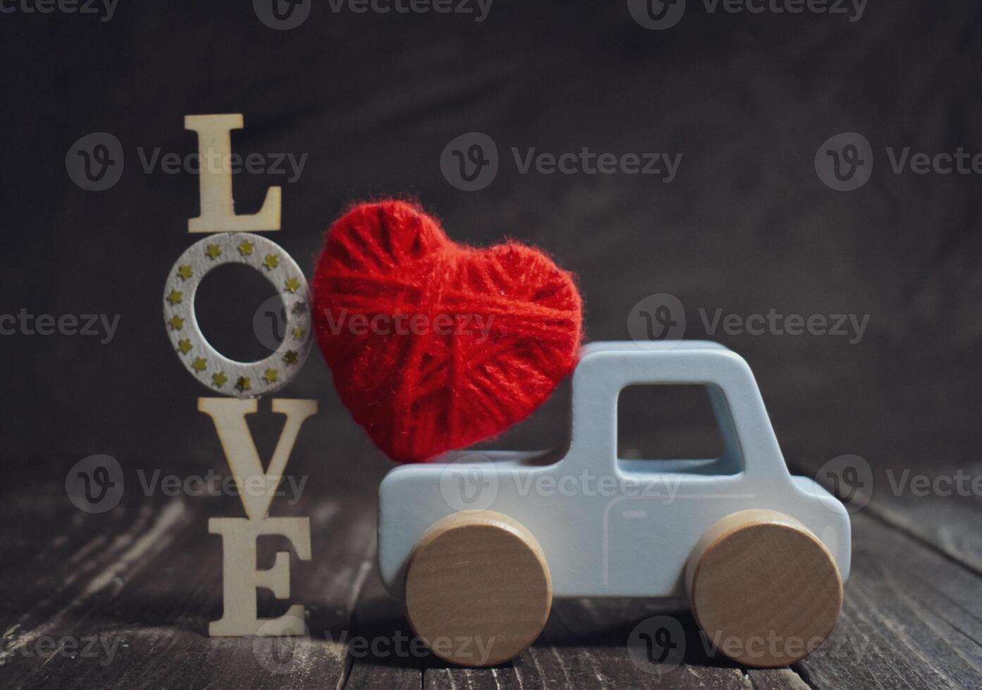 Toy car Valentine Day on wooden background photo