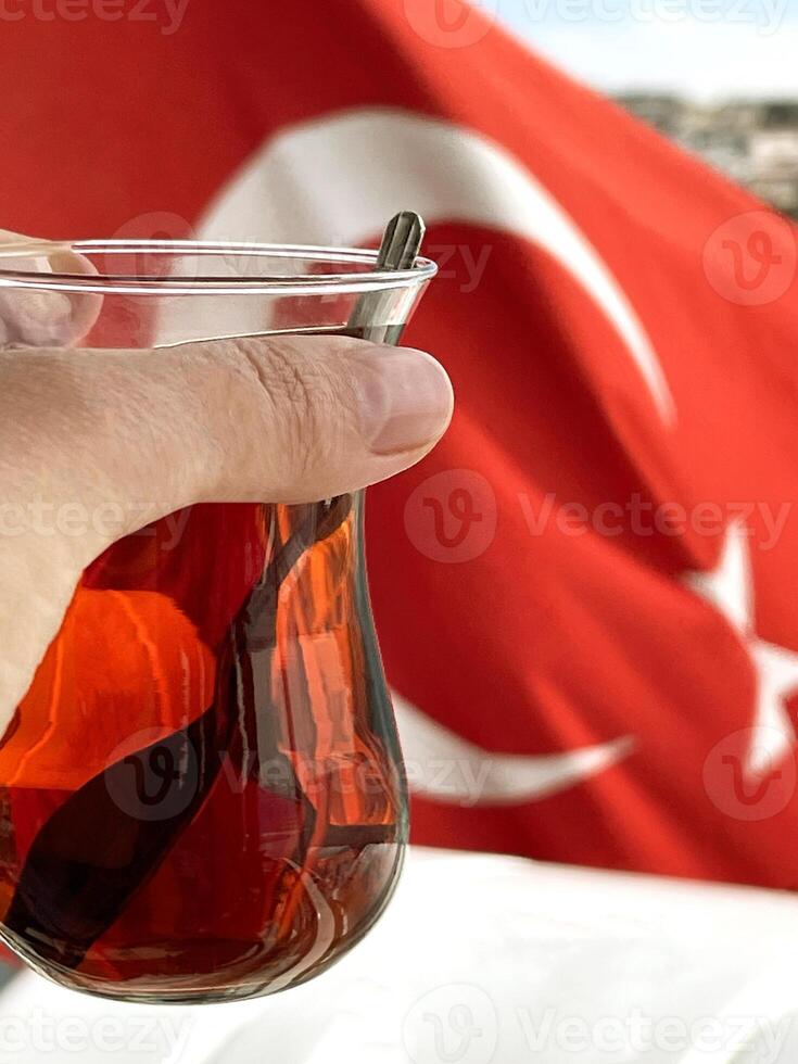 un taza de té en un mujer mano en contra el antecedentes de el turco bandera, bósforo y Estanbul foto