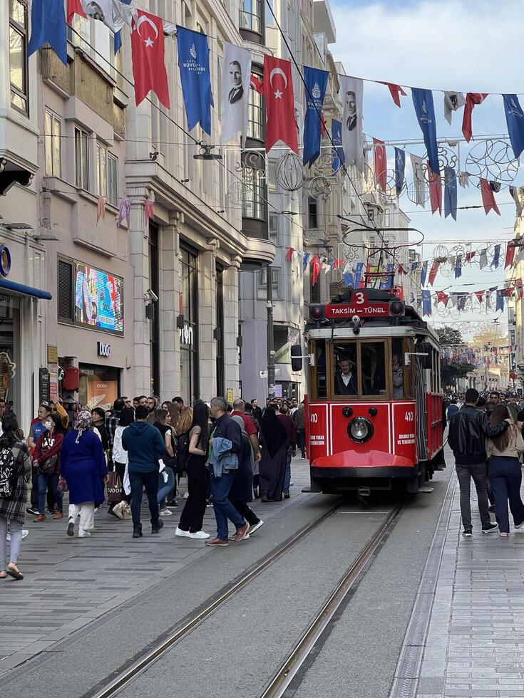 dieciséis de abril 2023 - Estanbul, Turquía - ciudad vida, el personas y famoso rojo tranvía en istiklal peatonal calle foto