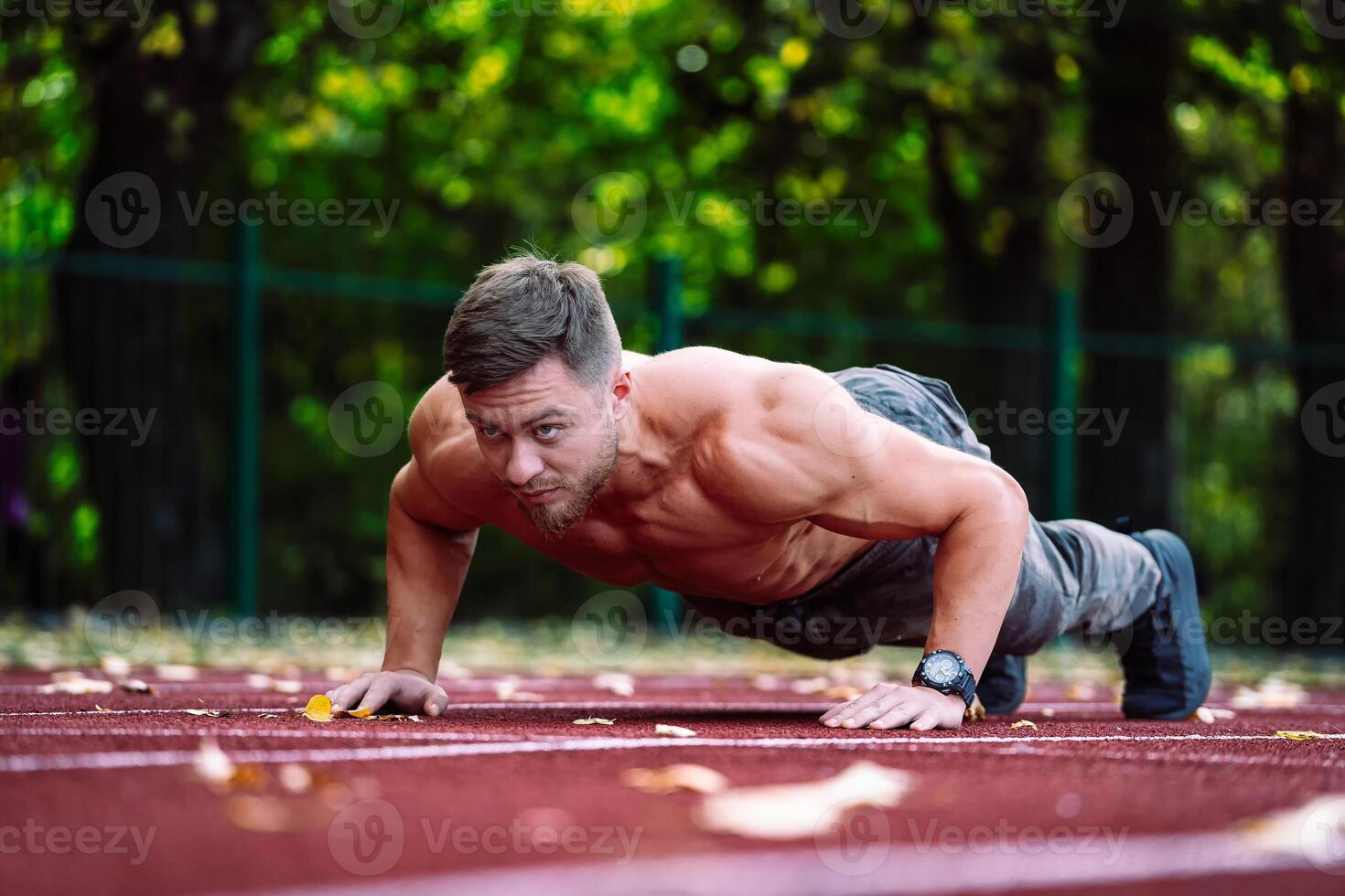 A Man Doing Push Ups on a Track photo