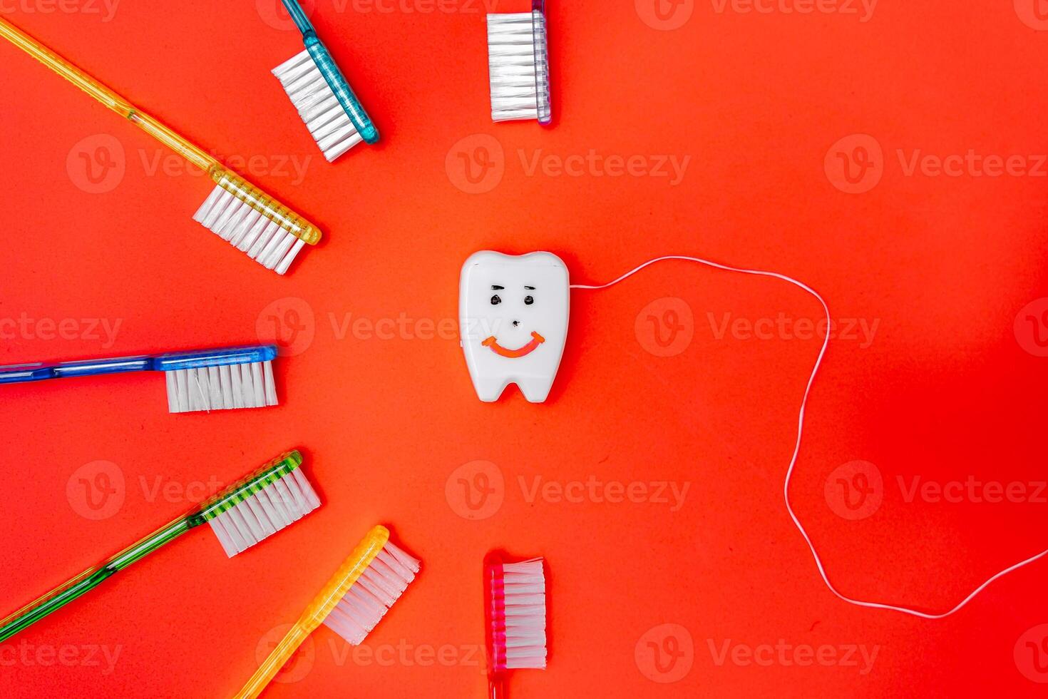 Arranging Dental Essentials in a Vibrant Circle. Toothbrushes and toothpaste arranged in a circle on a red background photo