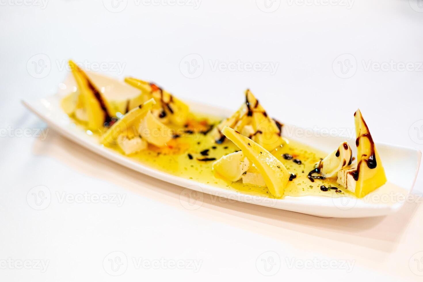 White Plate with Delicious Food on Table. A white plate topped with food on top of a table photo