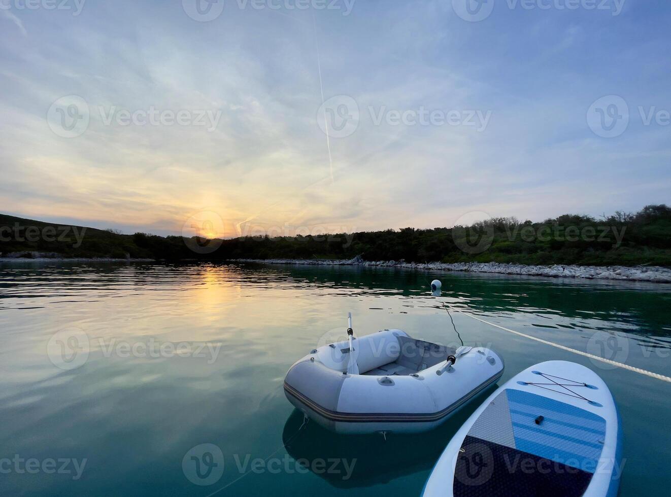 a boat is floating in the water at sunset photo