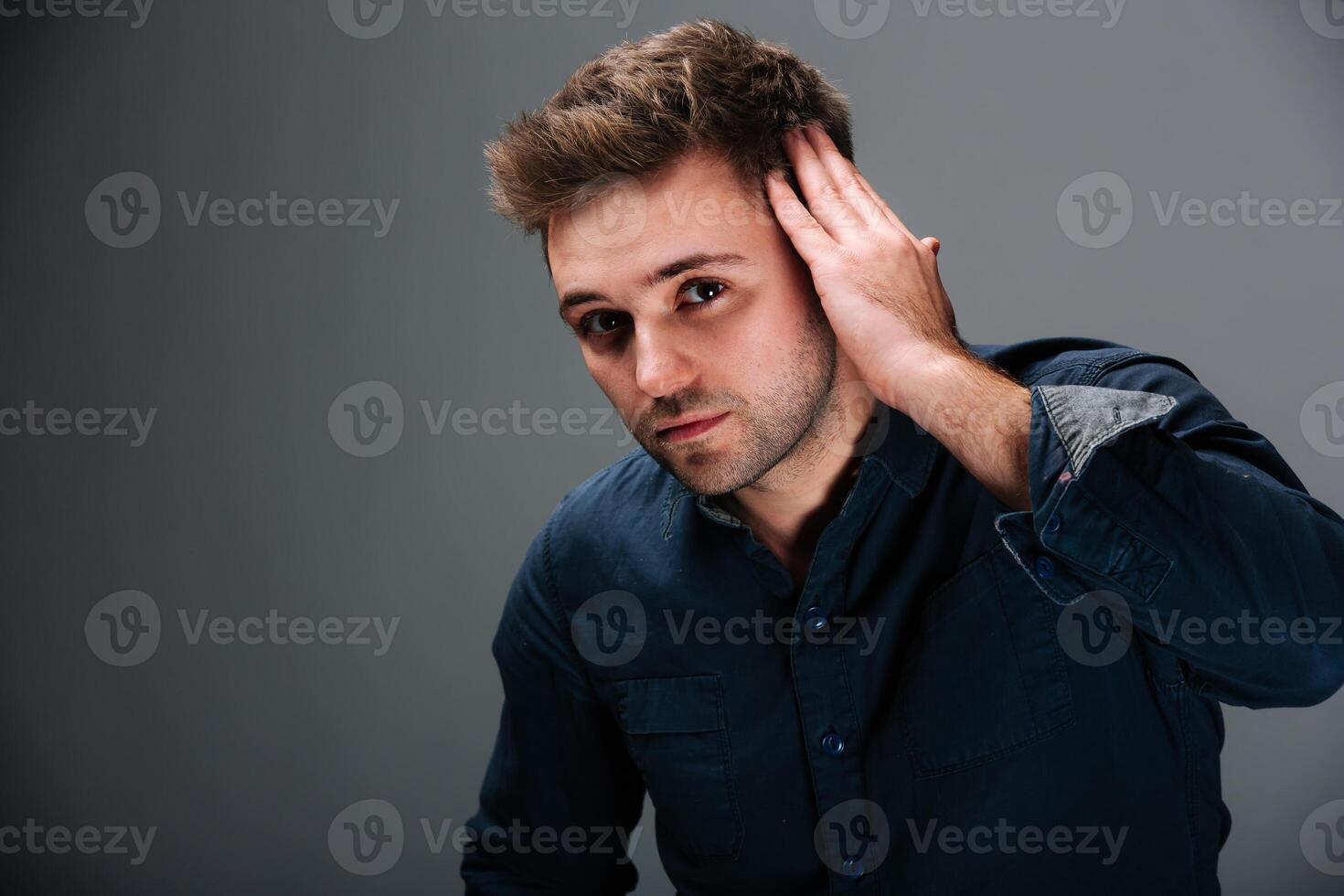 un hombre cubierta su orejas en malestar. un hombre es participación su manos a su orejas foto