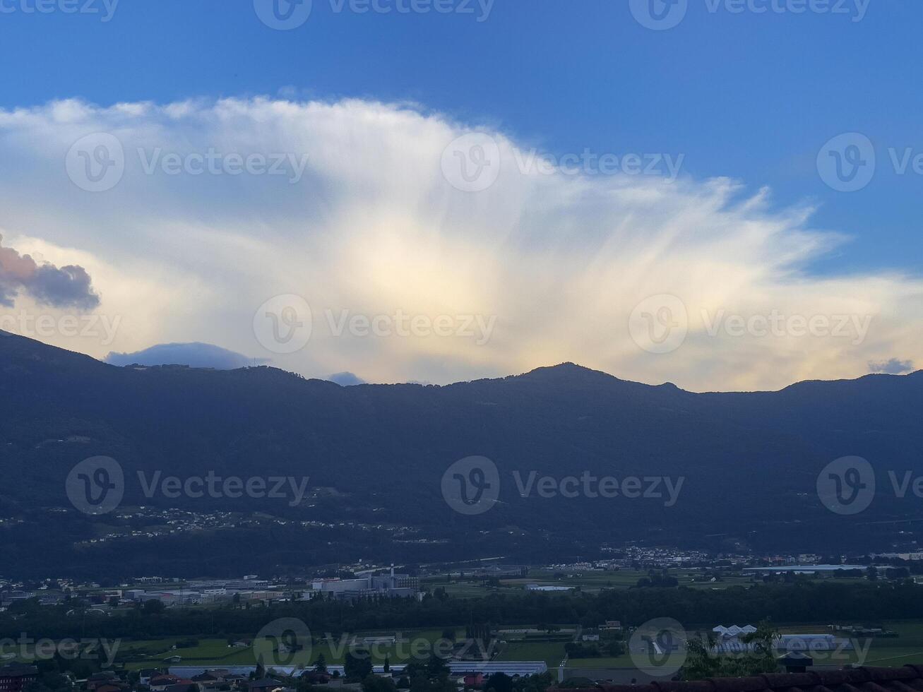 a view of the mountains and clouds from the top of a hill photo