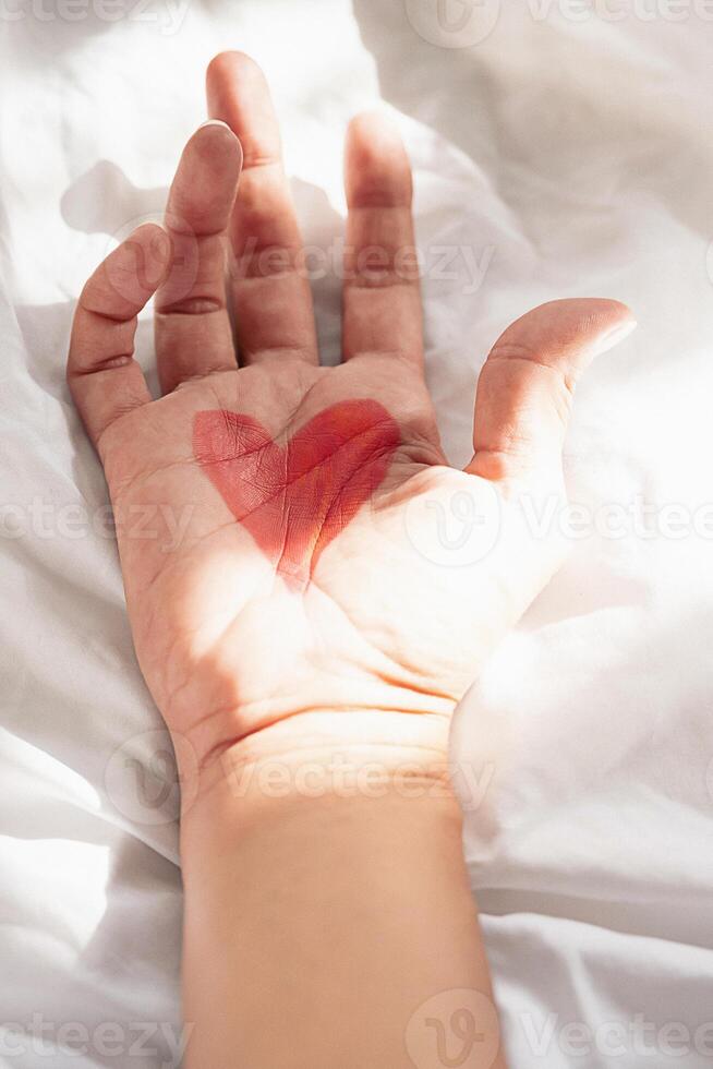 Heart shape drawing on the palm of hand. photo