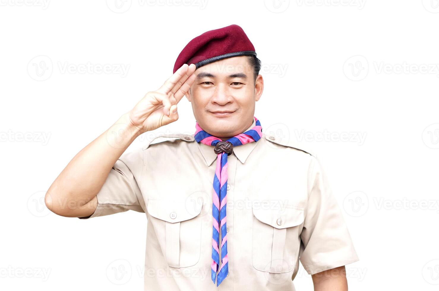 Handsome Asian man wear boy scout uniform, red cap, blue and pink striped scarf, make hand sign symbol, isolated on white background. Concept, educational career with uniform in school, Thailand. photo