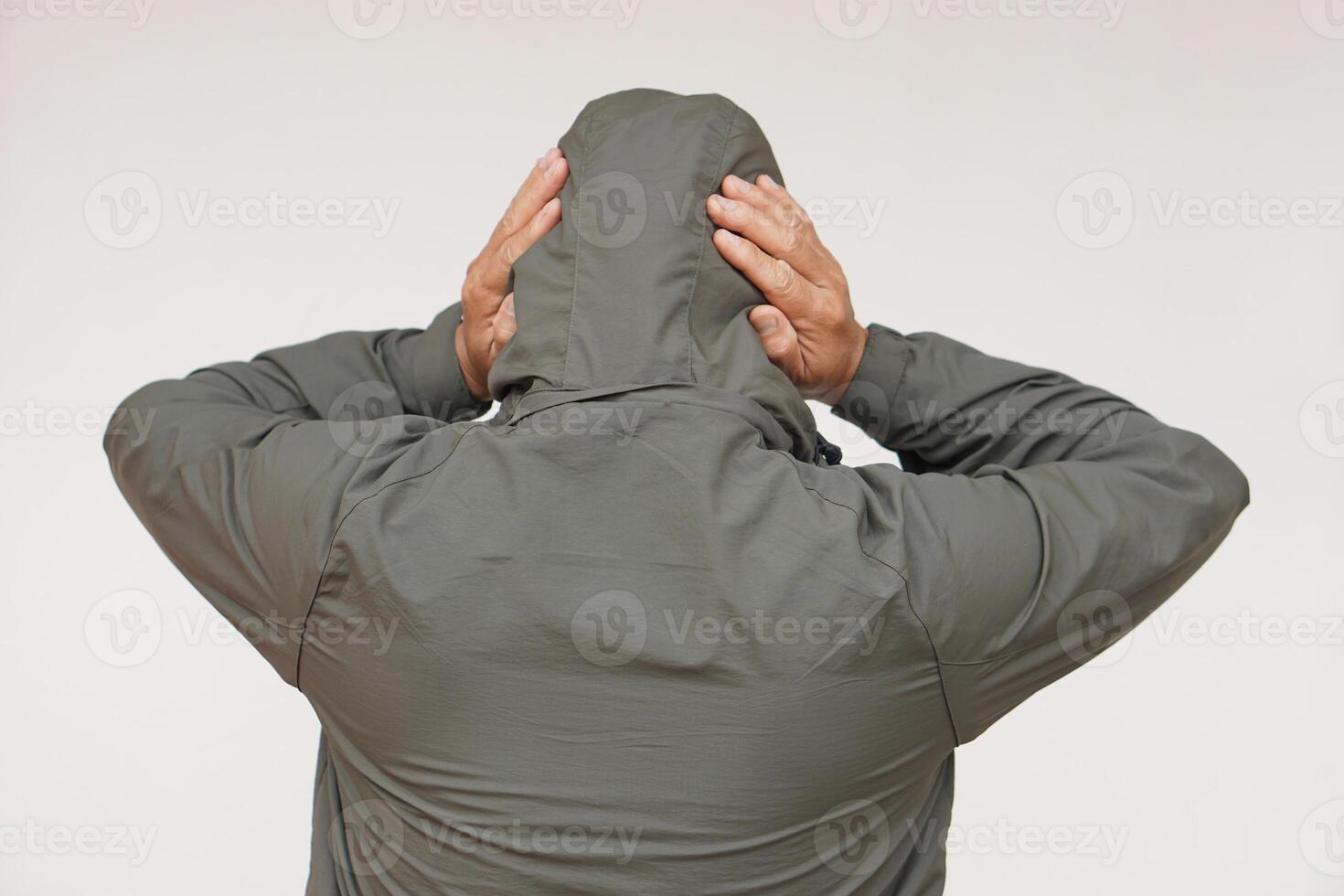 Back view of man wears hoodie, uses his hands to cover ears. Concept, don't want to listen or hear anything. Distressed by noise. Avoid listening to noise of complains or negative words. photo