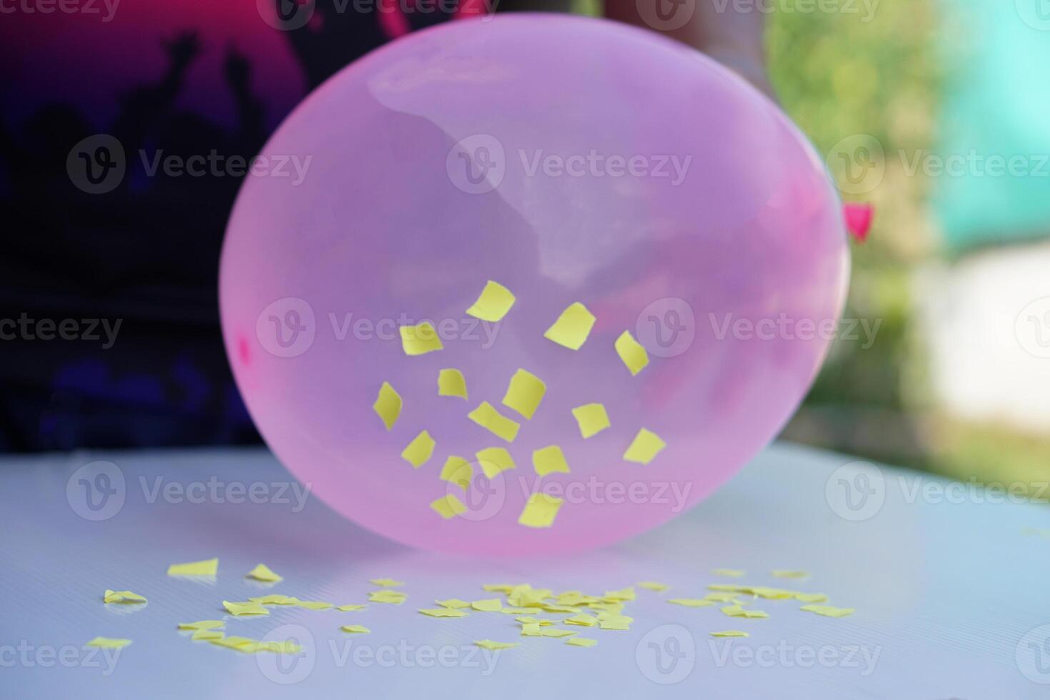 Closeup hand hold pink balloon to do science experiment about static electricity from balloon and pieces of paper. Concept, Science lesson, fun and easy experiment. Education. Teaching aids. photo
