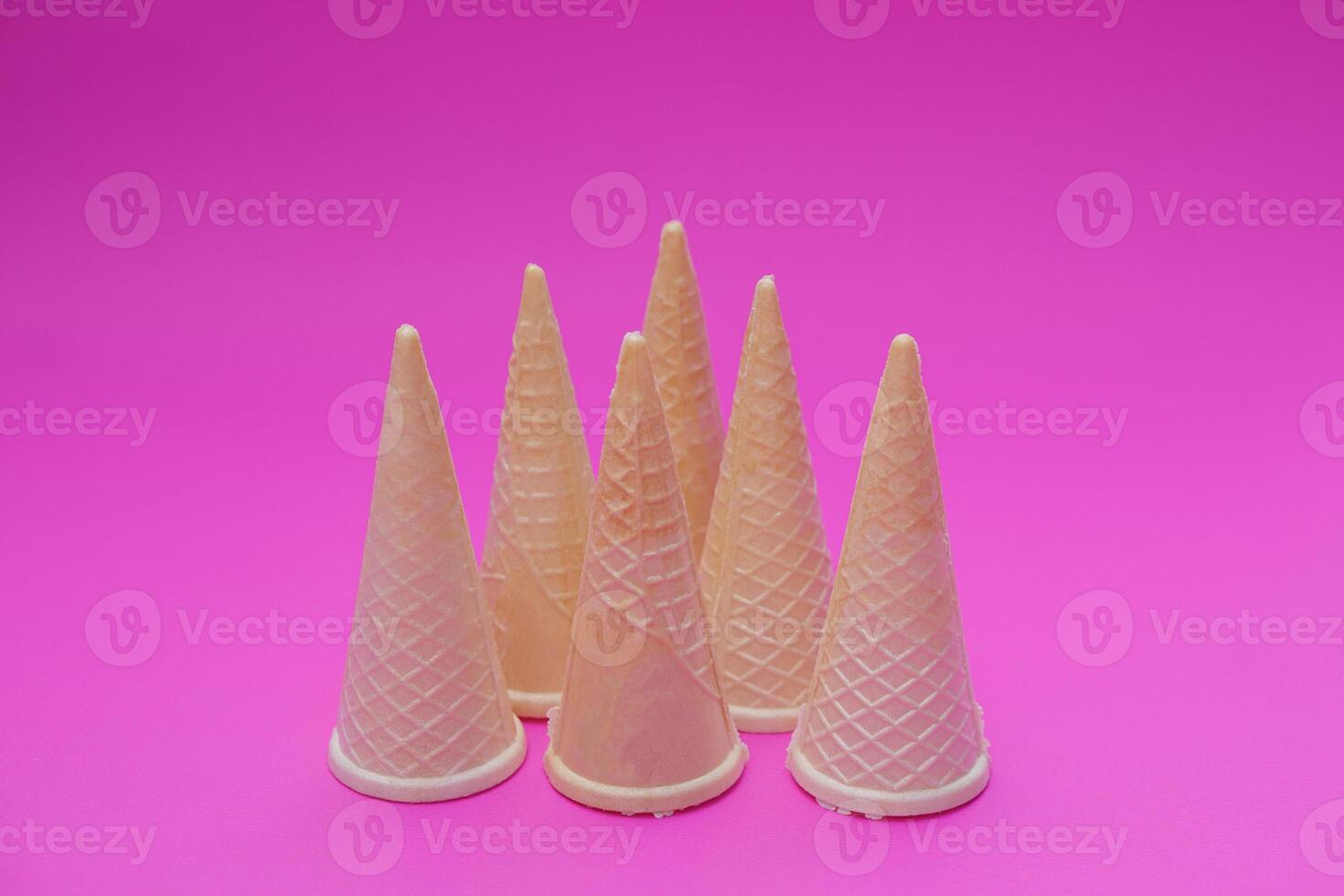 Empty crispy waffle ice cream cones isolated on pink background. Concept, part of pattern of ice creams in cone shape. Snack and dessert. copy space for text. photo