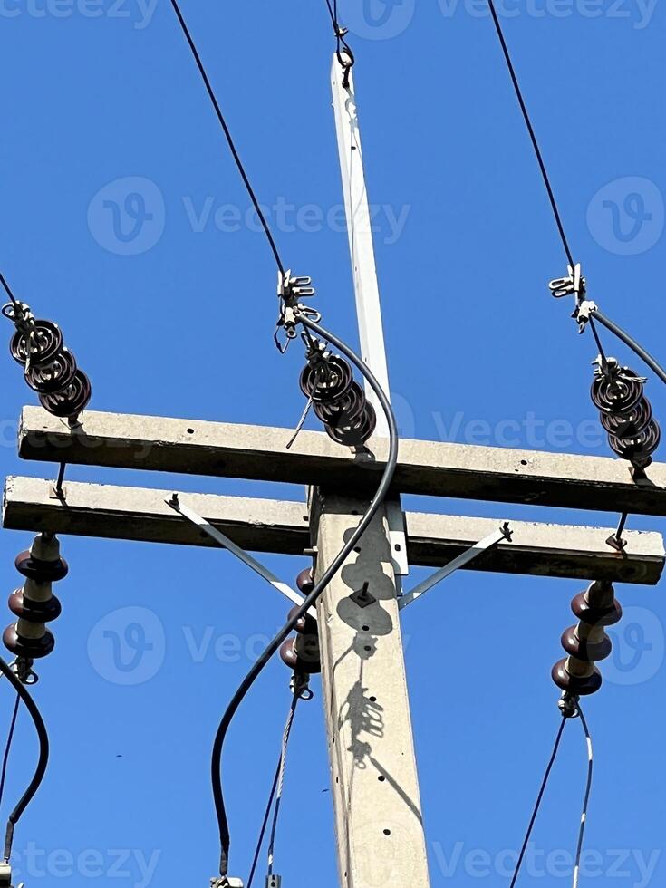 electric pole with power lines and wires on a background of blue sky photo