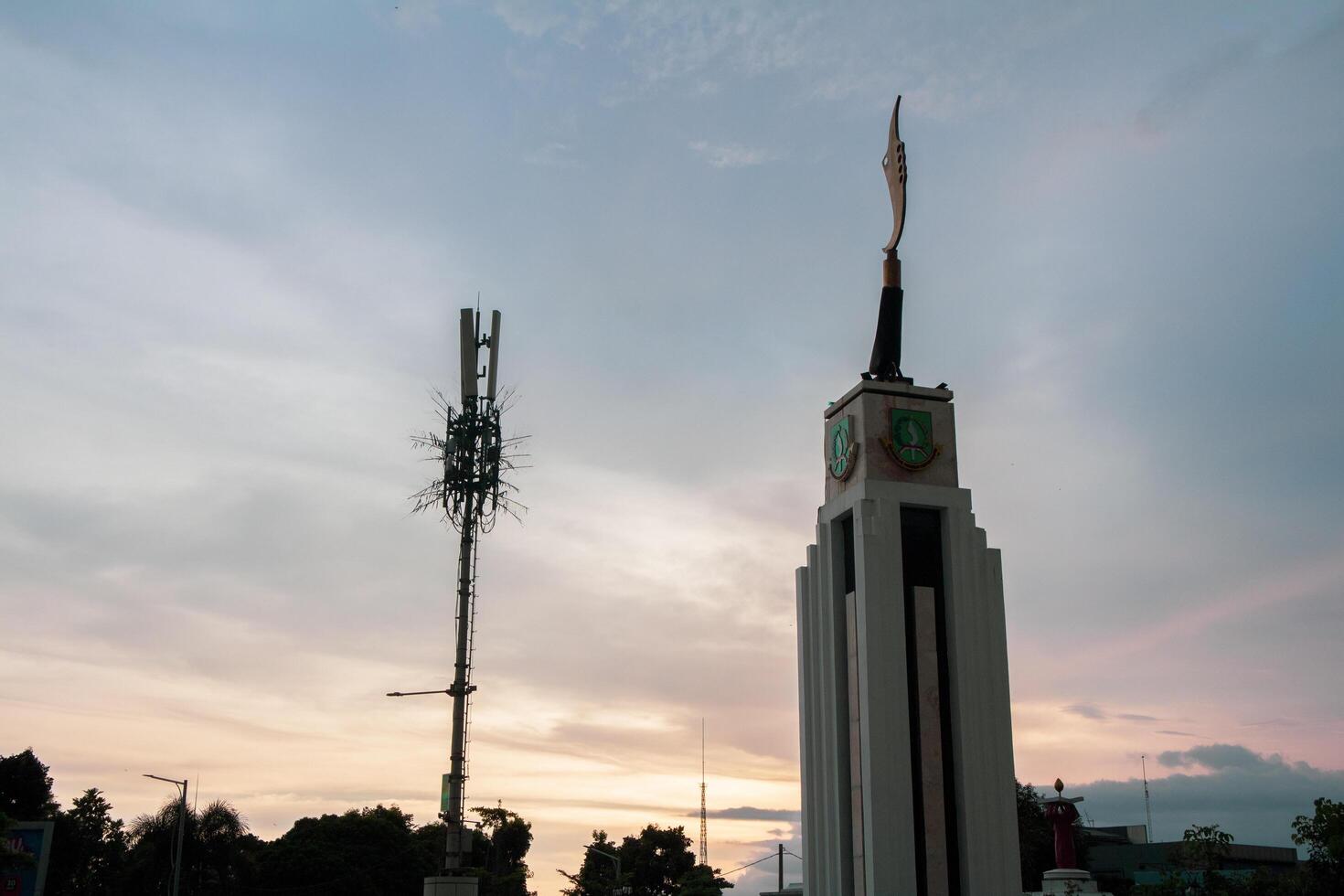 Sukabumi, Indonesia - January 14th 2024 - Kujang Monument, Sukabumi City Square or tugu Kujang Alun Alun Kota Sukabumi with Sunset Sky cloud on Twilight photo
