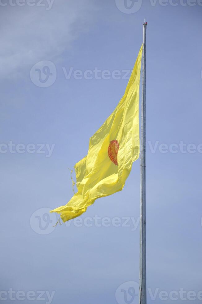 yellow buddha flag on blue sky photo