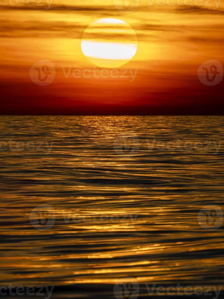 golden sun rays reflection on the sea at sunset photo