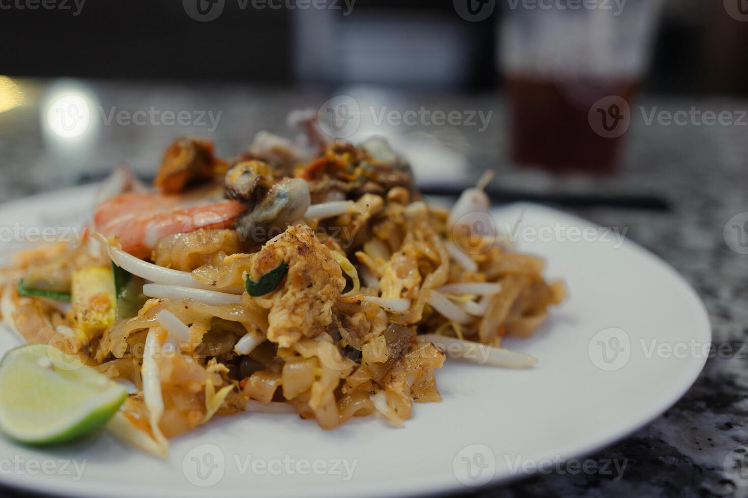 Fried Thai noodles, pat thai with seafood and eggs. photo