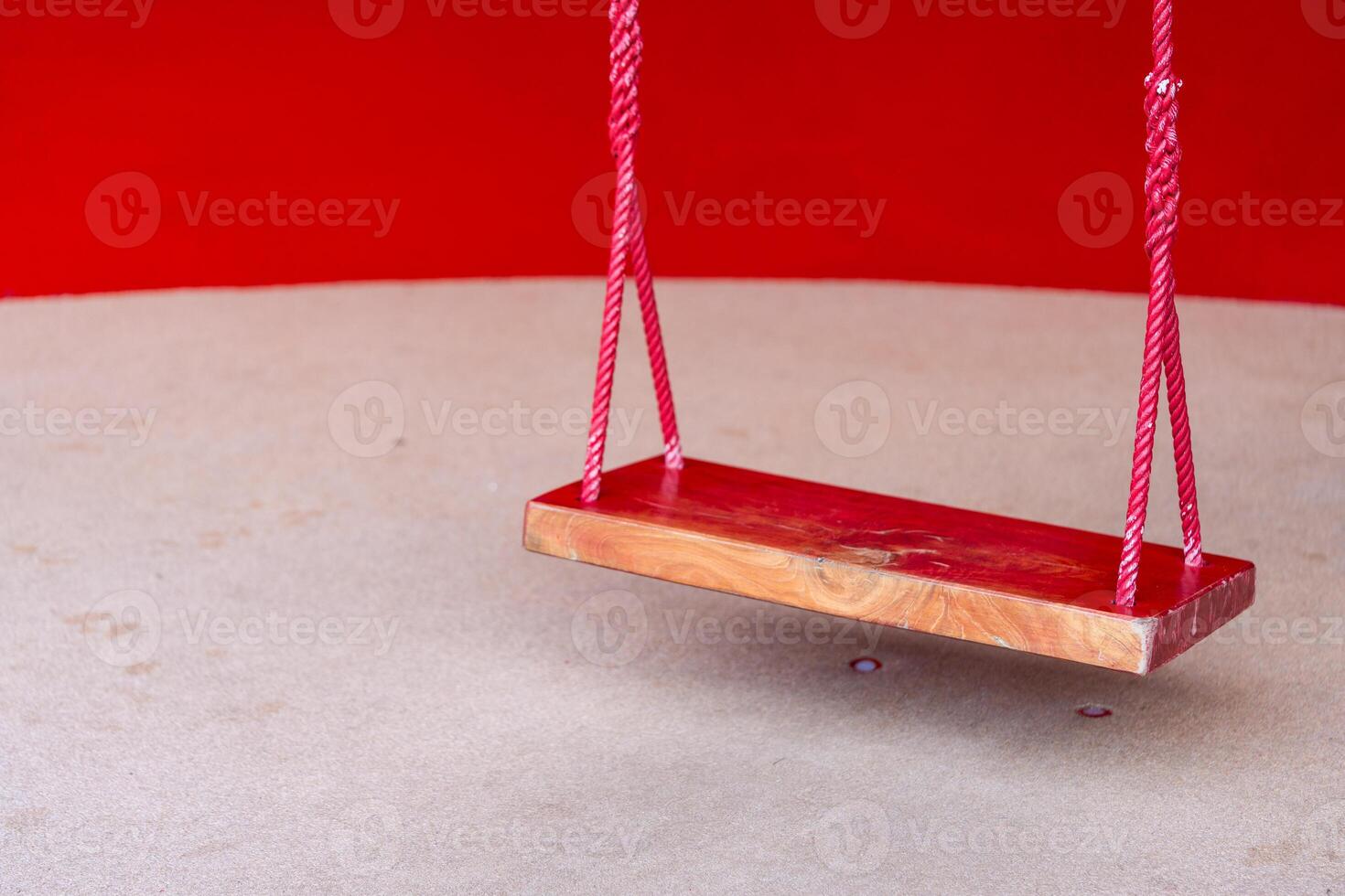 Wooden red swing for entertaining the smallest boys and girls photo