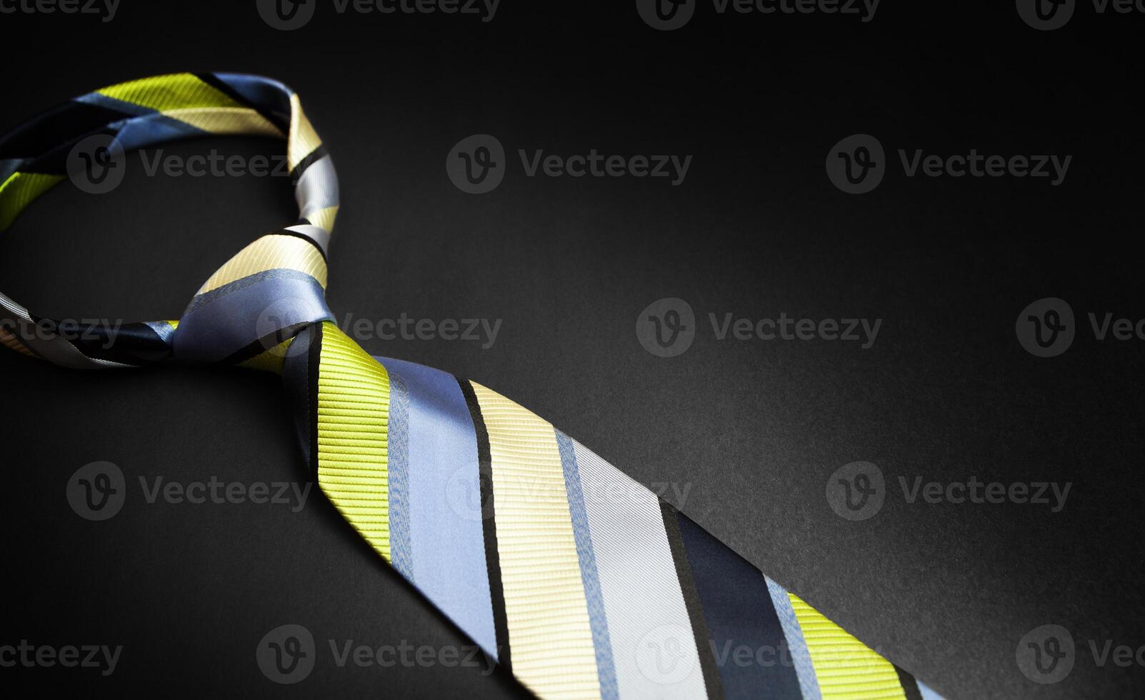 Men's striped tie in different colors isolated on black background. photo