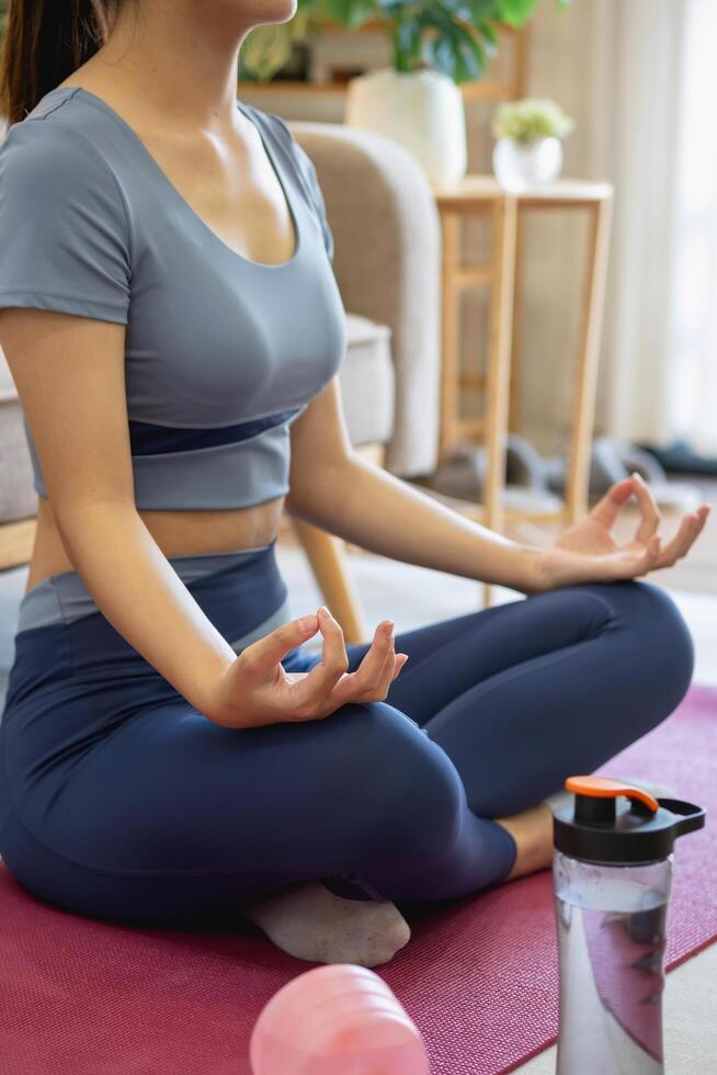 Healthy young woman doing breathing exercises at home, beautiful woman meditating at home with eyes closed, practicing yoga, doing pranayama techniques Mindfulness meditation concept photo