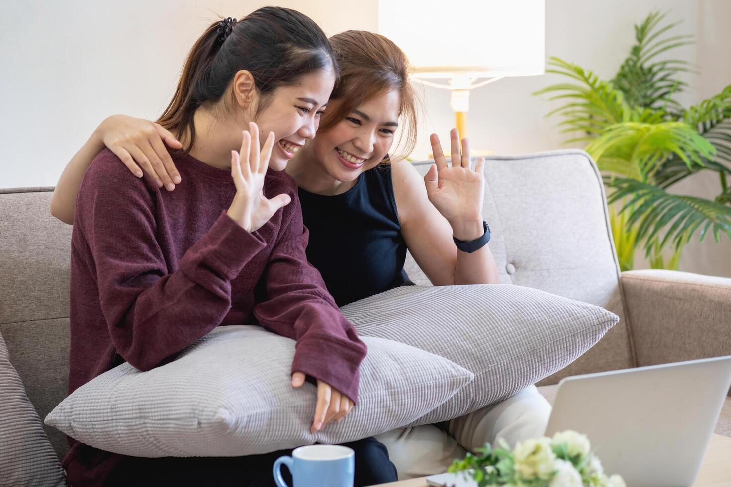 Relaxed young Asian woman enjoying relaxation on a comfy sofa at home. The beautiful girl calmly relaxes and breathes fresh air in the house. Watch movies and social networks. photo