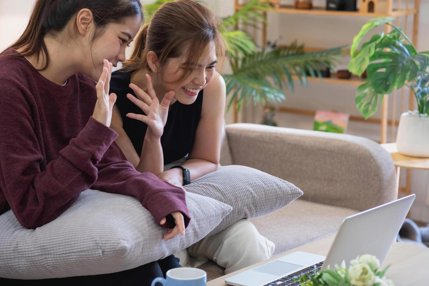 Relaxed young Asian woman enjoying relaxation on a comfy sofa at home. The beautiful girl calmly relaxes and breathes fresh air in the house. Watch movies and social networks. photo