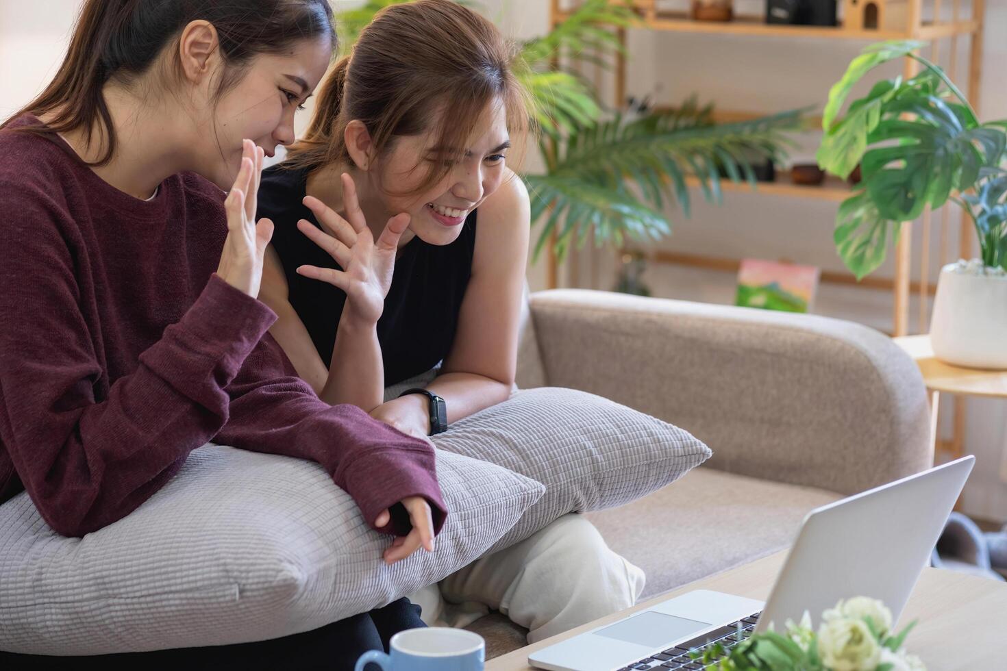 Relaxed young Asian woman enjoying relaxation on a comfy sofa at home. The beautiful girl calmly relaxes and breathes fresh air in the house. Watch movies and social networks. photo