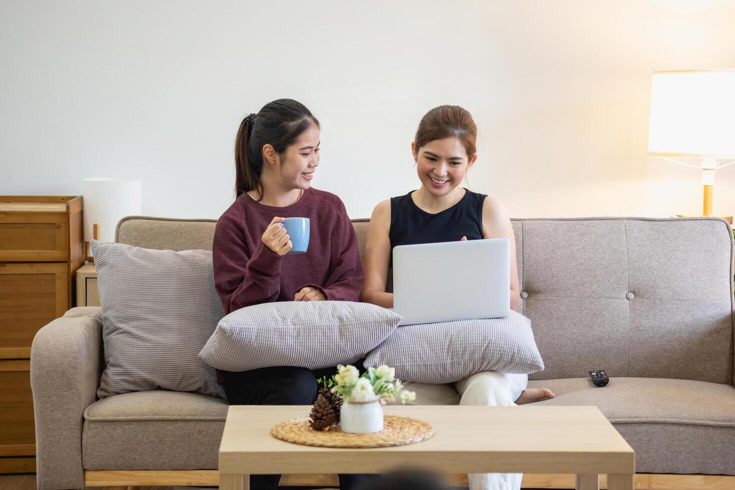 Relaxed young Asian woman enjoying relaxation on a comfy sofa at home. The beautiful girl calmly relaxes and breathes fresh air in the house. Watch movies and social networks. photo