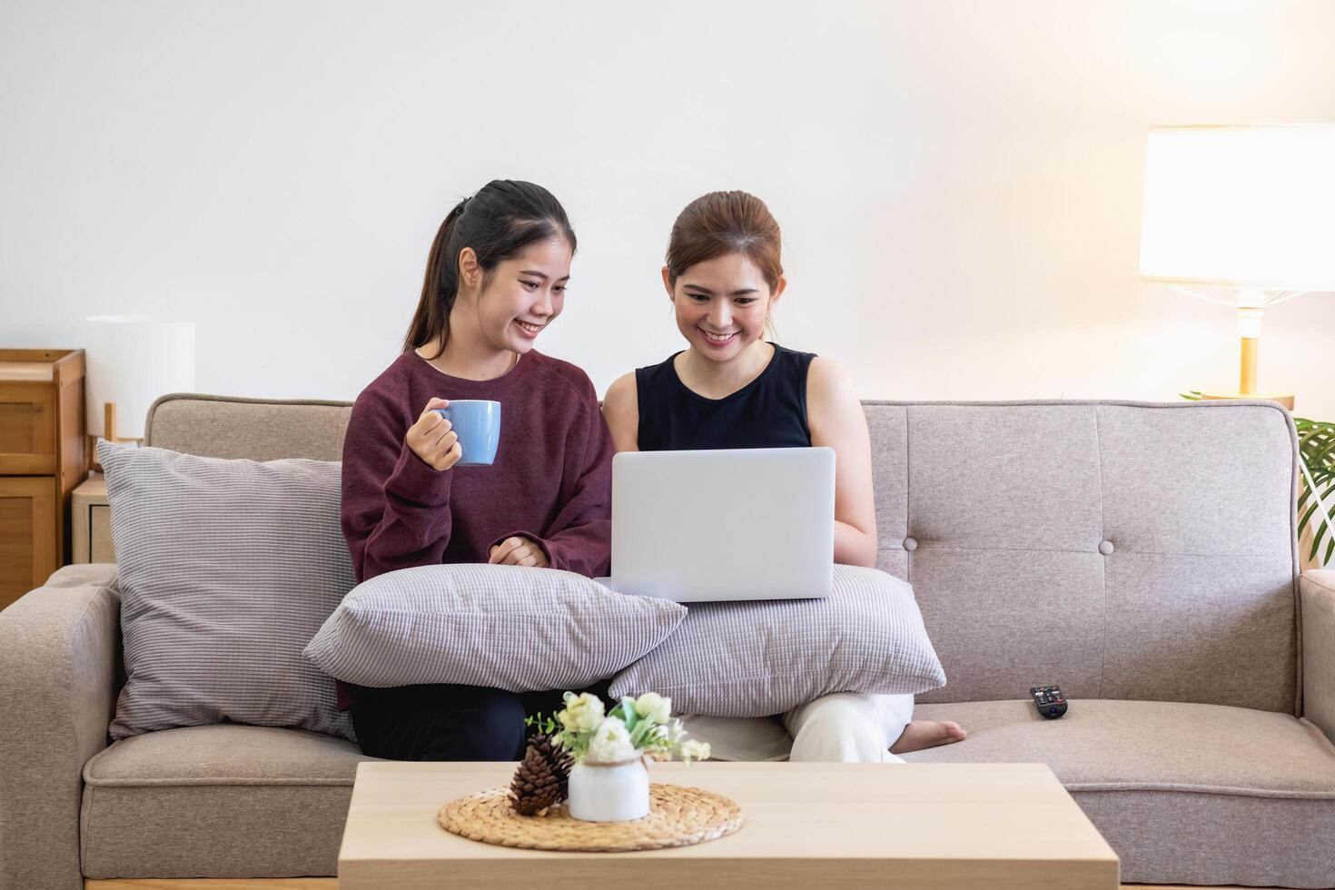 relajado joven asiático mujer disfrutando relajación en un confortable sofá a hogar. el hermosa niña tranquilamente relaja y respira Fresco aire en el casa. reloj películas y social redes foto