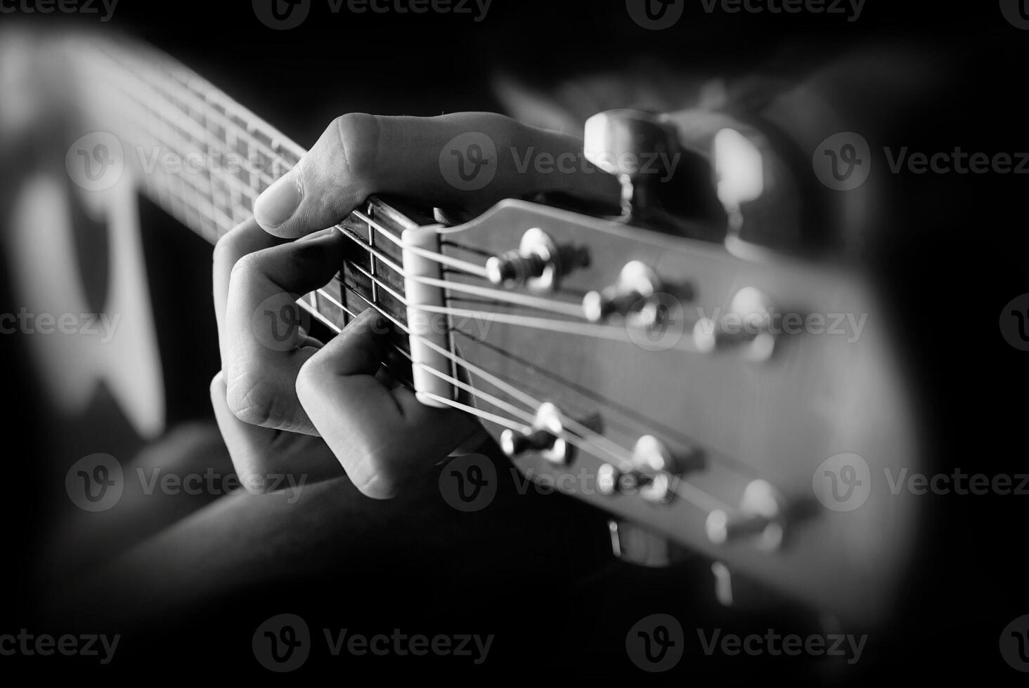 Cerca de la mano del hombre tocando la guitarra foto