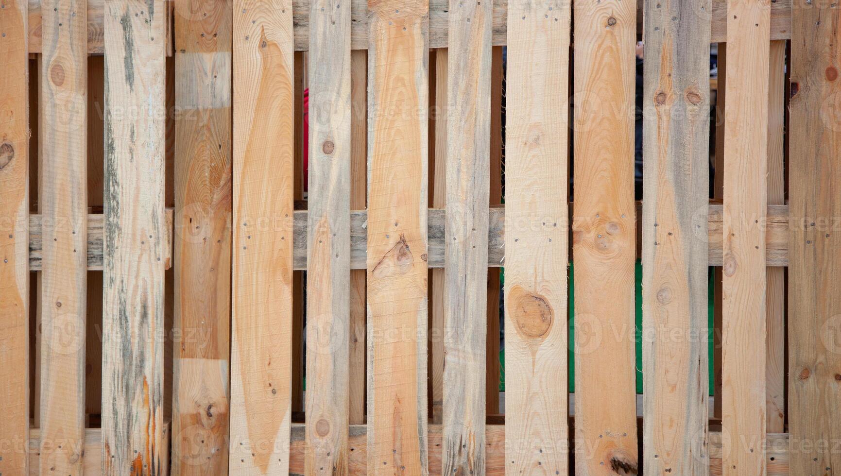 Wooden fence. Vertical boards knocked down by nails photo