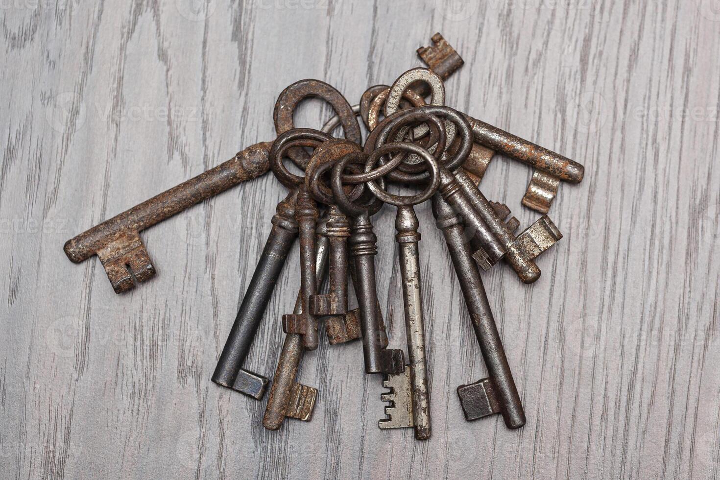 Bunch of old keys on dark wooden background, close up photo