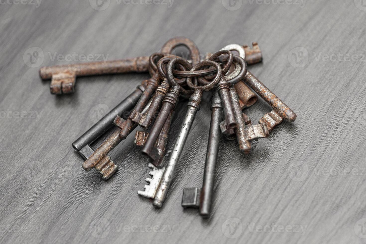 Bunch of old keys on dark wooden background, close up photo
