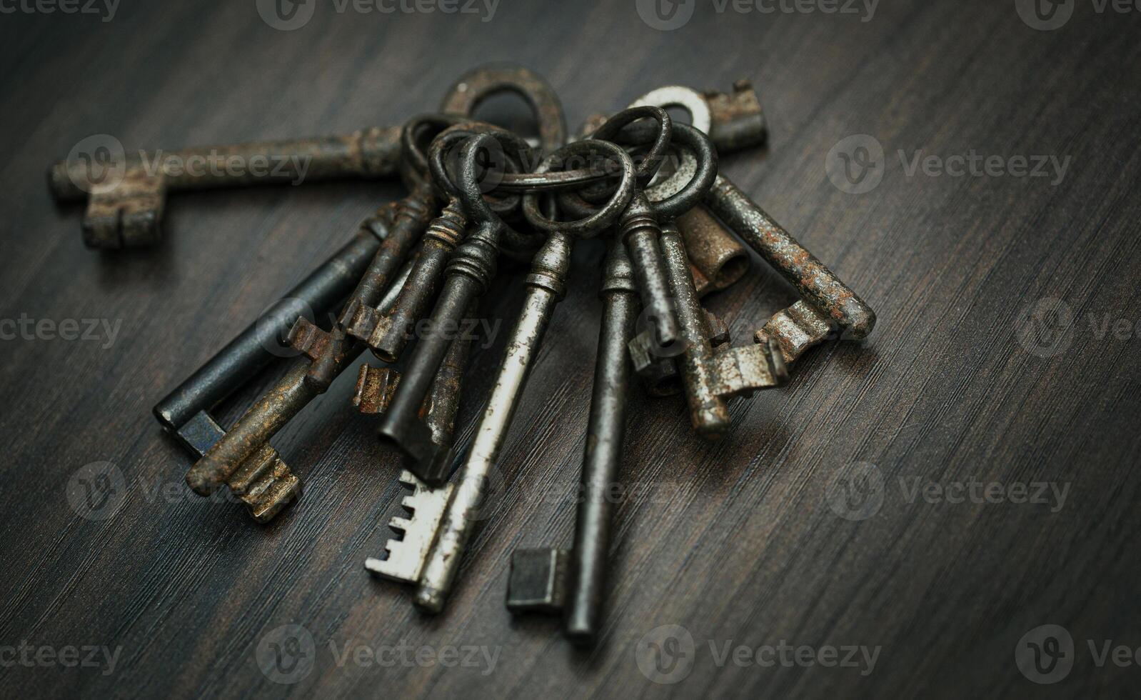Bunch of old keys on dark wooden background, close up photo