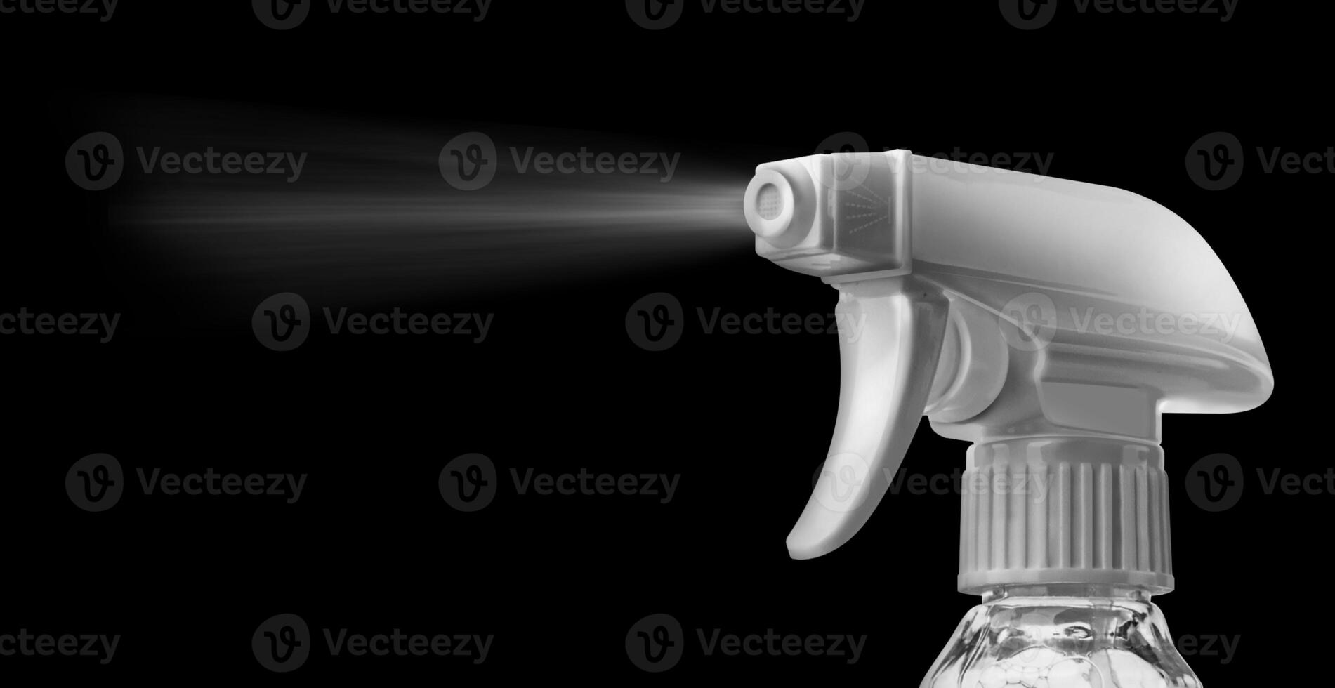 Close view of a plastic spray bottle's head for dispersion isolated on a black background photo